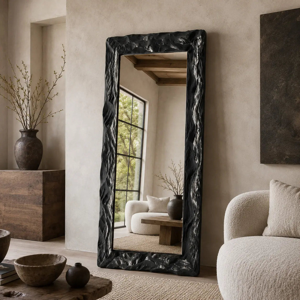 Obsidian rectangular mirror with a sculptural black frame in an interior setting